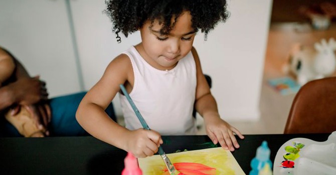 Ett barn som målar med målarfärg.
